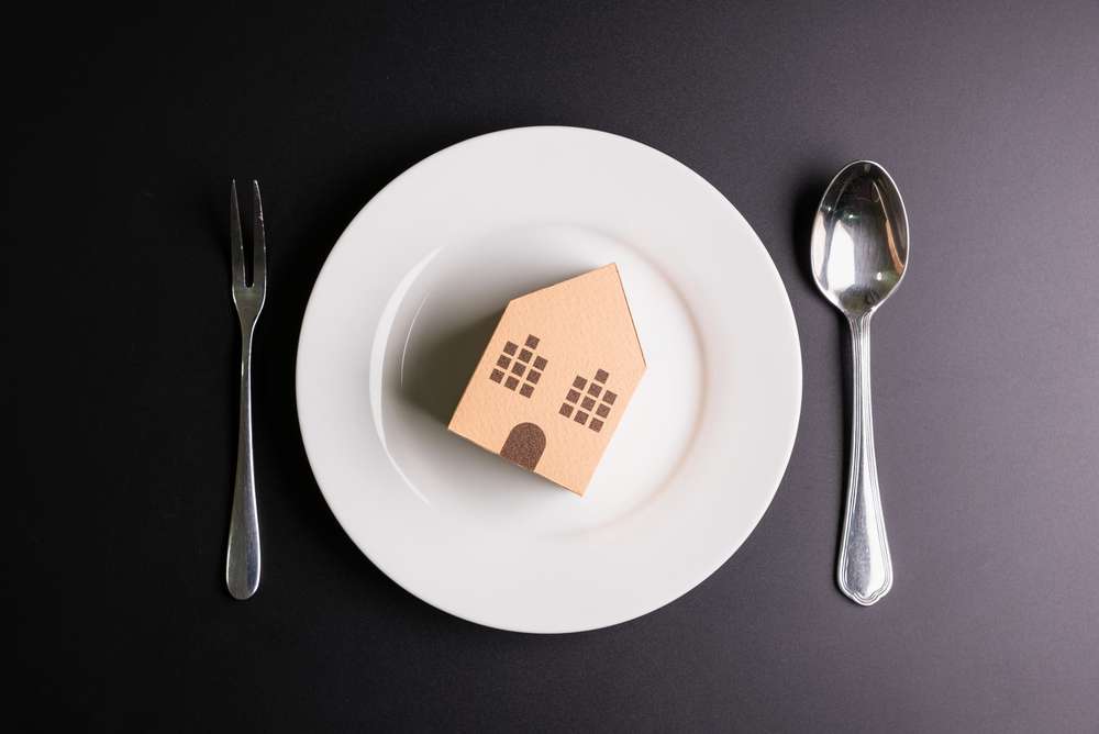 Paper,House,In,A,White,Dish,On,Black,Background,With